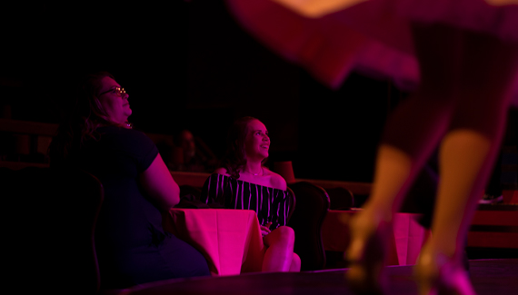 Two women watching the Alhambra Theatre stage